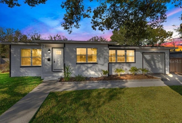 view of front of house featuring a yard and a garage