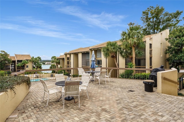 view of patio with a water view and a community pool