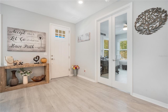 foyer with light hardwood / wood-style floors and french doors