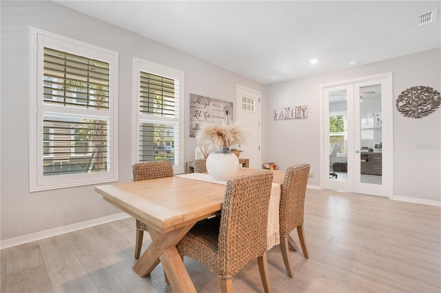 dining area with light hardwood / wood-style floors and french doors