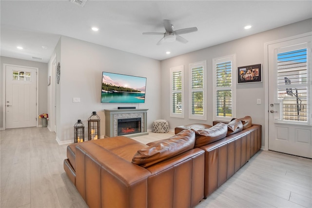 living room with ceiling fan, light hardwood / wood-style flooring, and a healthy amount of sunlight