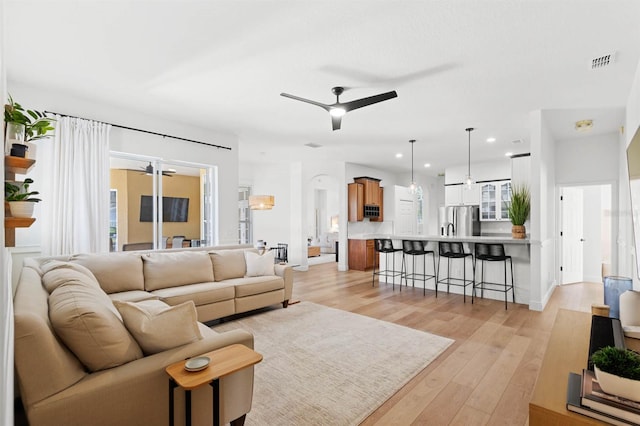 living room with light hardwood / wood-style floors and ceiling fan