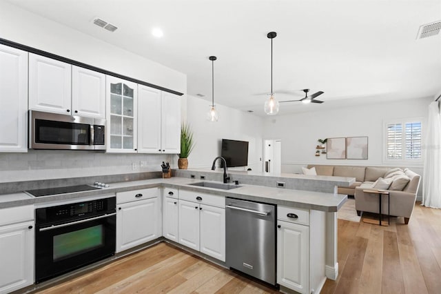 kitchen with white cabinets, sink, kitchen peninsula, and stainless steel appliances