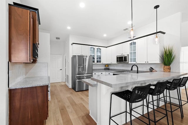 kitchen featuring appliances with stainless steel finishes, white cabinetry, and a breakfast bar area