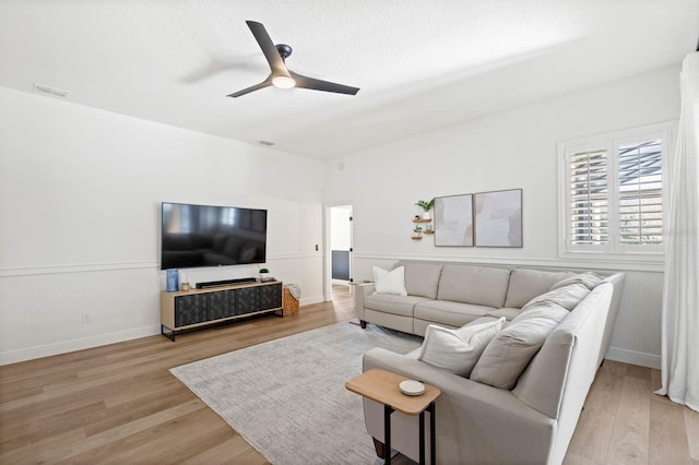 living room with light wood-type flooring and ceiling fan