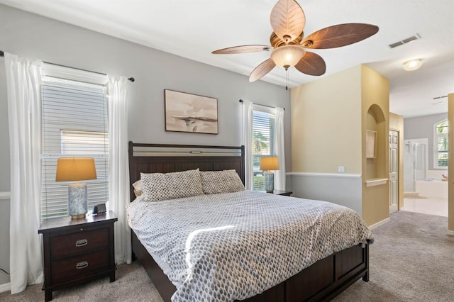 bedroom featuring connected bathroom, ceiling fan, and light colored carpet