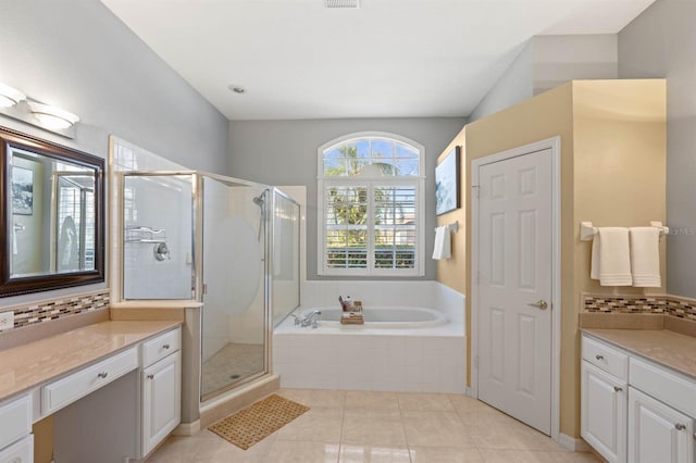 bathroom featuring tile patterned floors, decorative backsplash, vanity, and plus walk in shower