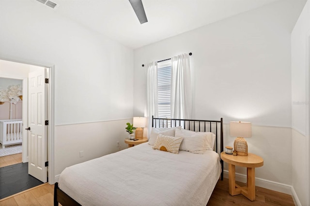 bedroom with dark hardwood / wood-style flooring and ceiling fan