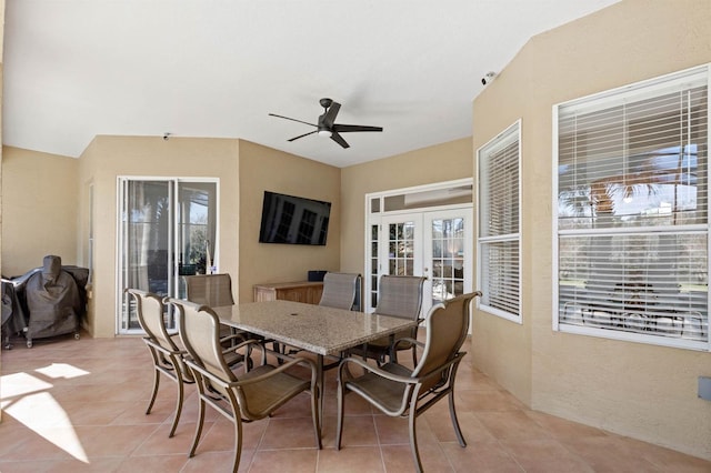 dining area featuring ceiling fan, french doors, and light tile patterned floors