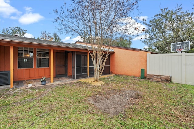 rear view of house with a yard and a sunroom