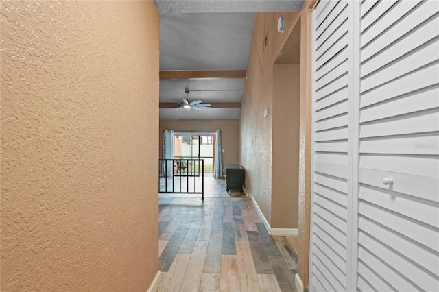 corridor featuring a textured ceiling and hardwood / wood-style flooring