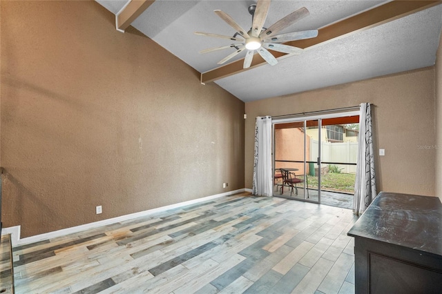 interior space with a textured ceiling, ceiling fan, light hardwood / wood-style floors, and vaulted ceiling with beams