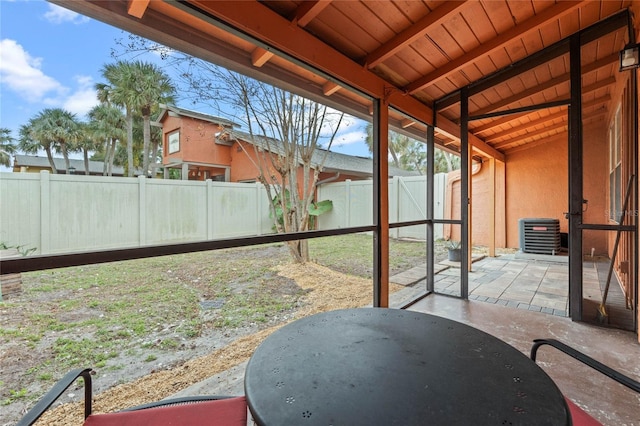 sunroom / solarium featuring vaulted ceiling with beams