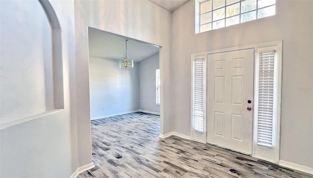 entrance foyer featuring light hardwood / wood-style floors and a notable chandelier