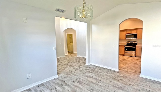 interior space featuring light hardwood / wood-style floors, vaulted ceiling, and an inviting chandelier