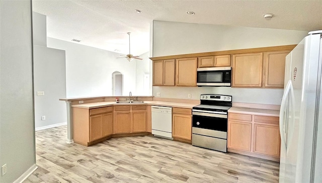 kitchen with kitchen peninsula, appliances with stainless steel finishes, vaulted ceiling, ceiling fan, and sink