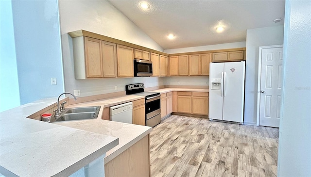 kitchen with light brown cabinets, lofted ceiling, sink, kitchen peninsula, and stainless steel appliances