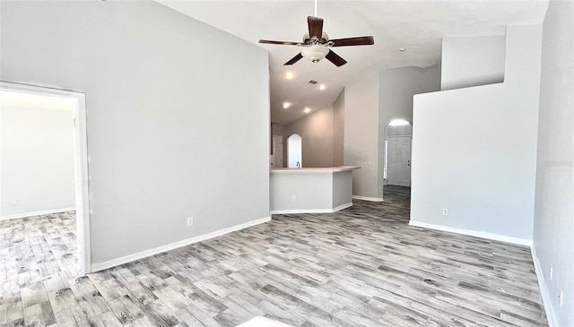 unfurnished living room featuring ceiling fan, high vaulted ceiling, and light hardwood / wood-style floors