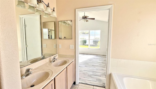 bathroom featuring vanity, lofted ceiling, a bath, tile patterned flooring, and ceiling fan