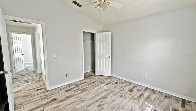 unfurnished bedroom featuring light wood-type flooring, a closet, vaulted ceiling, and ceiling fan