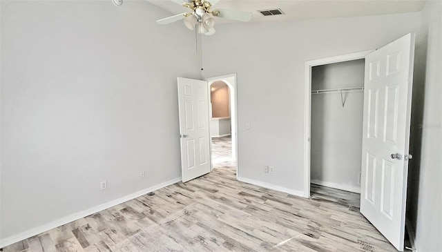 unfurnished bedroom with a closet, vaulted ceiling, ceiling fan, and light hardwood / wood-style flooring