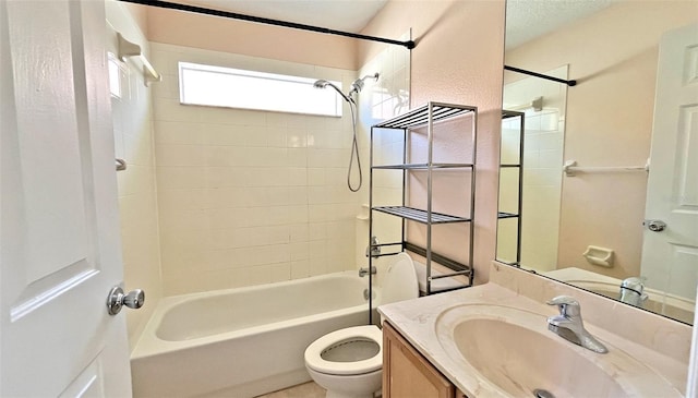 full bathroom with vanity, tiled shower / bath combo, and toilet