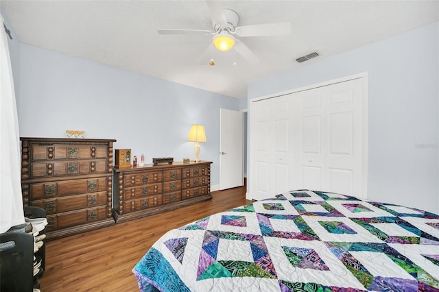 bedroom with hardwood / wood-style floors, ceiling fan, and a closet