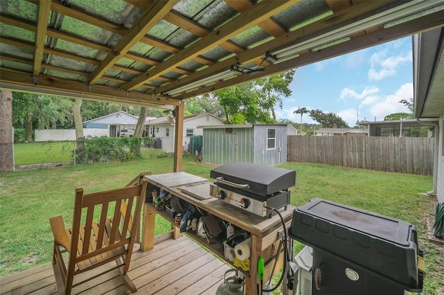 wooden deck featuring a storage shed and a lawn