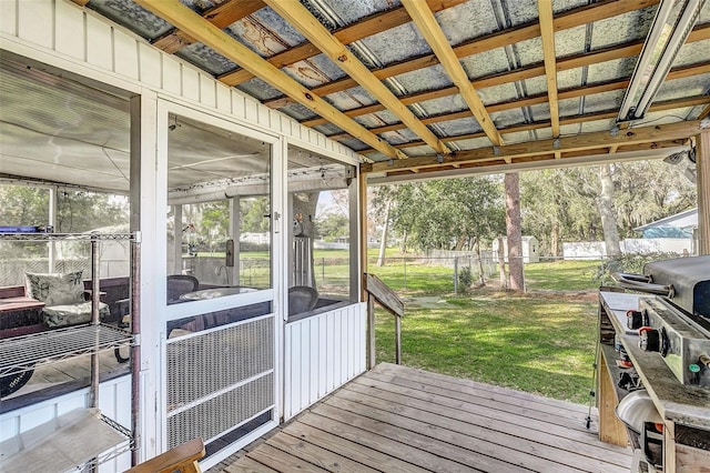 wooden deck featuring a sunroom and a lawn