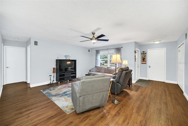 living room with ceiling fan, dark hardwood / wood-style flooring, and a textured ceiling