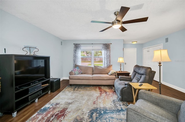 living room with ceiling fan, a textured ceiling, and dark hardwood / wood-style flooring