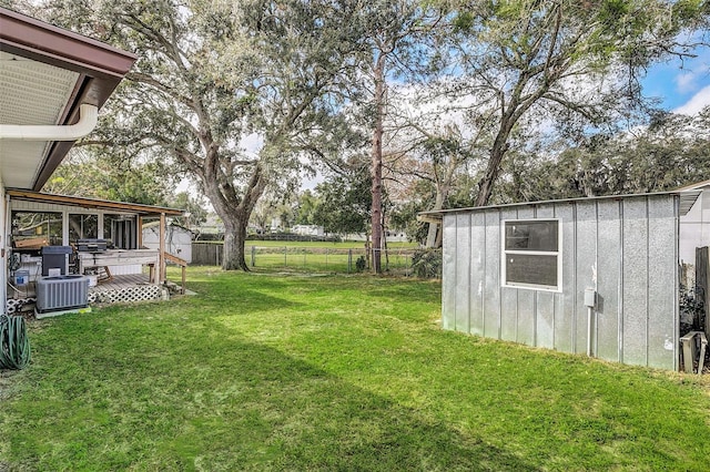 view of yard with central air condition unit and a storage unit