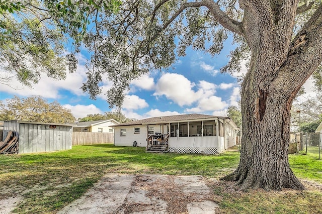 back of house with a sunroom and a yard