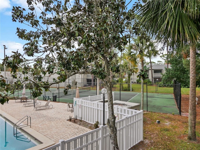 view of home's community featuring a patio and tennis court