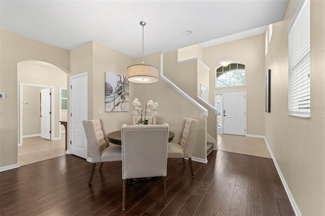 dining room with hardwood / wood-style flooring and a towering ceiling