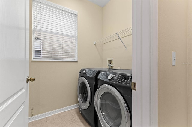 clothes washing area with separate washer and dryer and light tile patterned floors