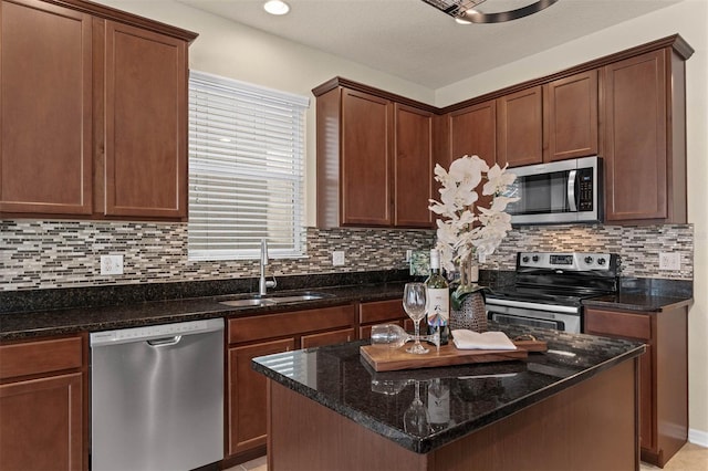 kitchen with stainless steel appliances, tasteful backsplash, sink, and dark stone counters