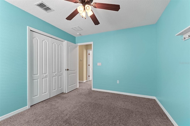 unfurnished bedroom featuring ceiling fan, carpet floors, a closet, and a textured ceiling