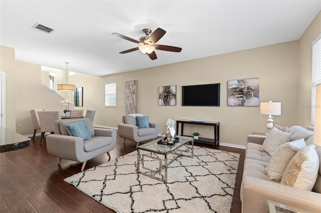 living room with dark hardwood / wood-style flooring and ceiling fan