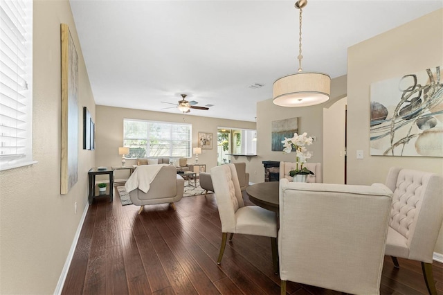 dining space with ceiling fan and dark hardwood / wood-style flooring