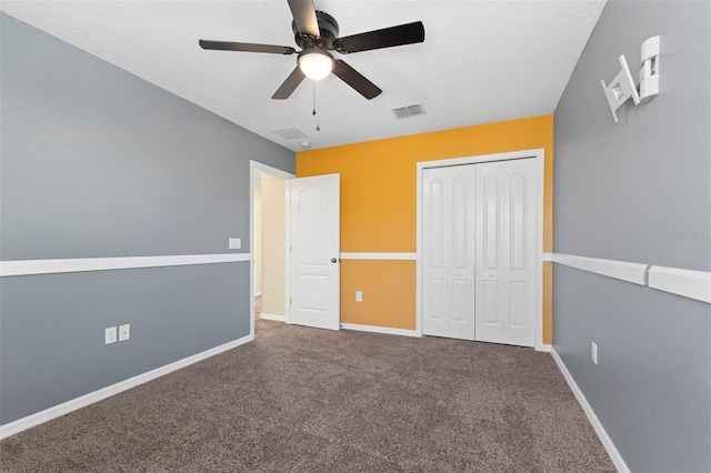 unfurnished bedroom with ceiling fan, carpet floors, a closet, and a textured ceiling