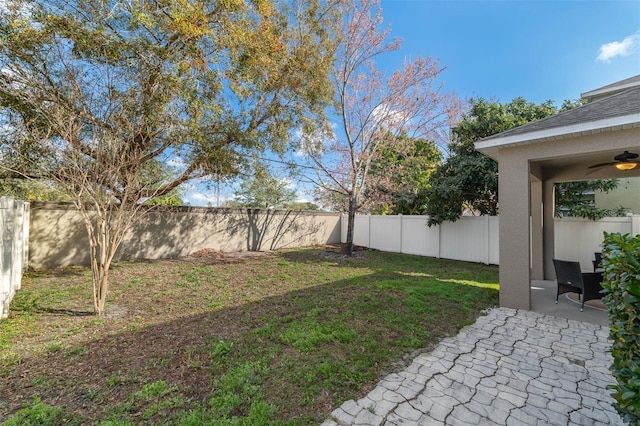 view of yard with ceiling fan and a patio area