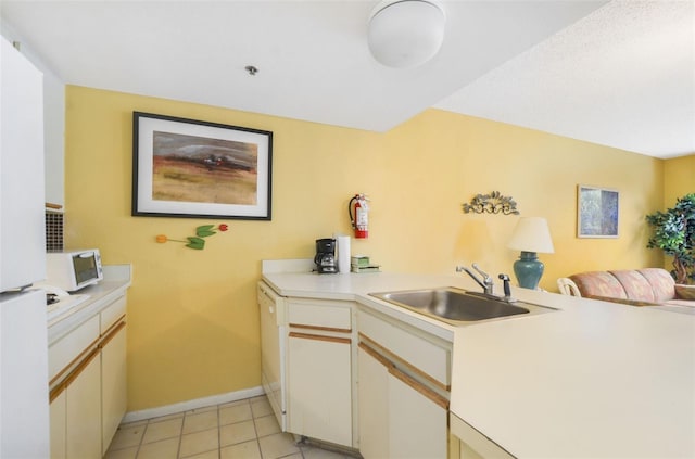 kitchen with kitchen peninsula, white cabinets, light tile patterned floors, and sink