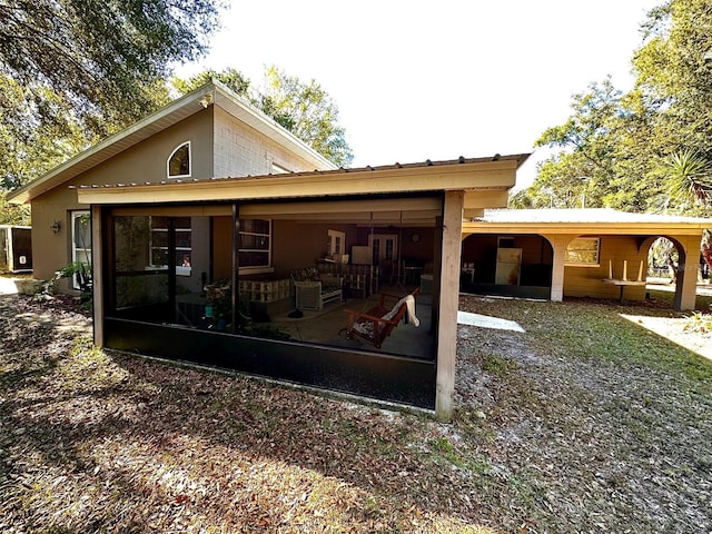 back of property with a sunroom