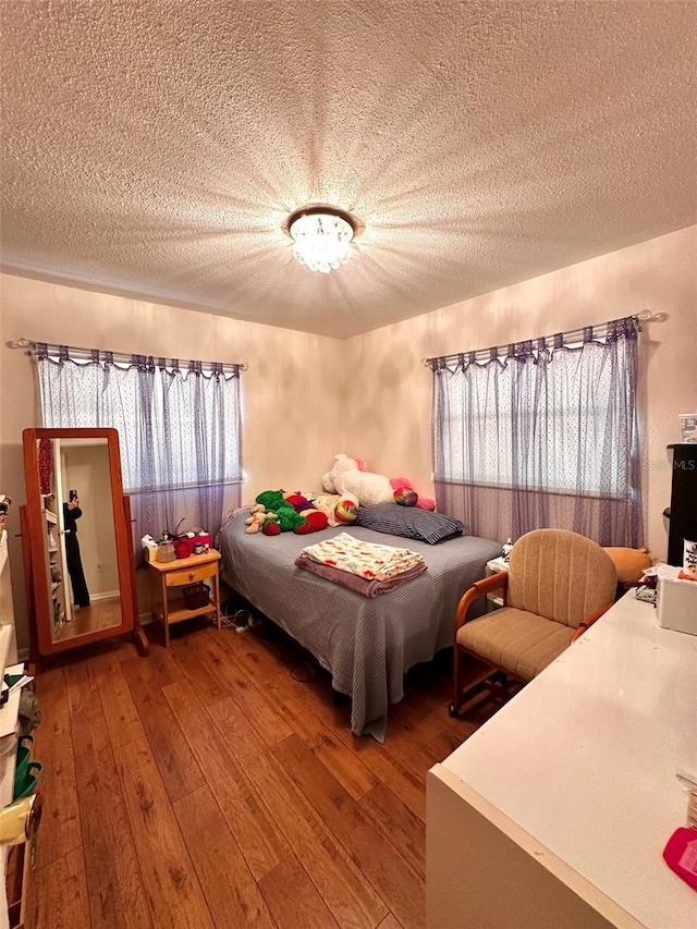 bedroom featuring a textured ceiling and hardwood / wood-style flooring