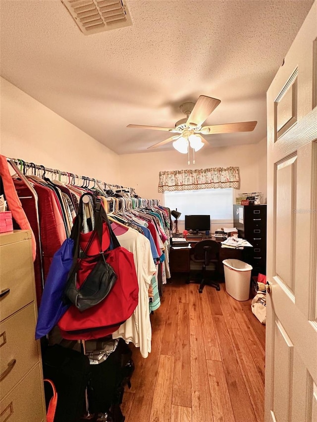 spacious closet with hardwood / wood-style flooring and ceiling fan