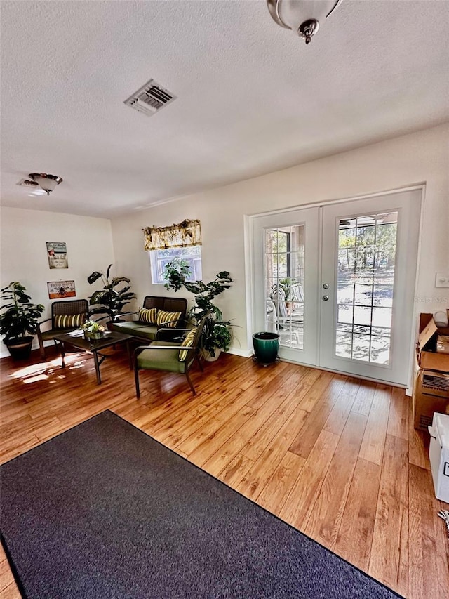 interior space featuring hardwood / wood-style floors, a textured ceiling, and french doors