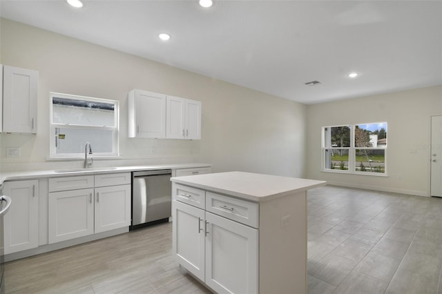 kitchen with sink, dishwasher, a center island, and white cabinets