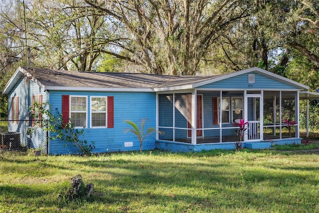 view of front of house with a sunroom and a front yard