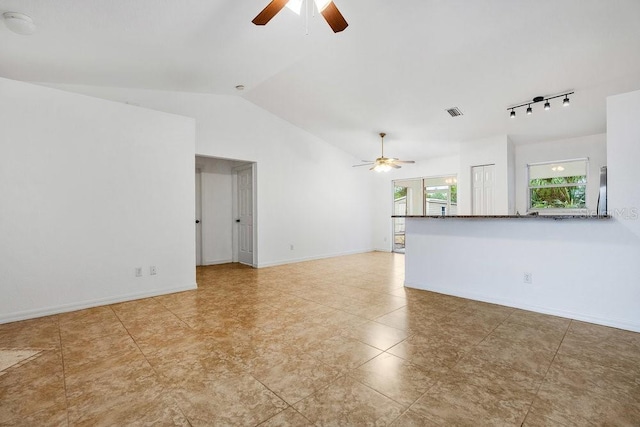 unfurnished living room with ceiling fan, rail lighting, and lofted ceiling